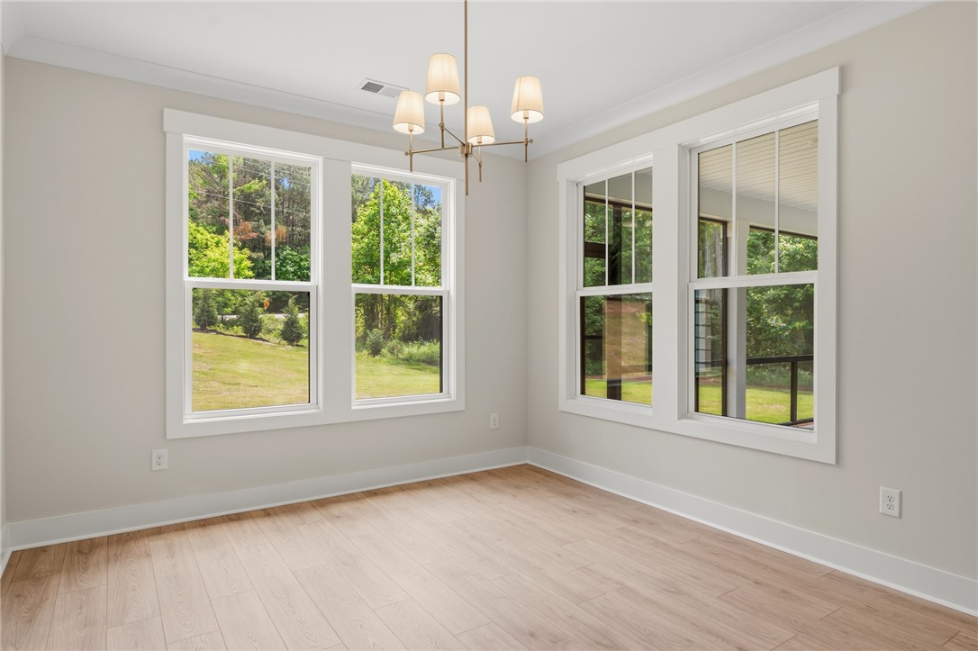 203 Timothy Court Anderson, SC 29621 - Photo 9 of 40 A refined ceiling fixture illuminates a bright, airy room with elegant wood flooring.