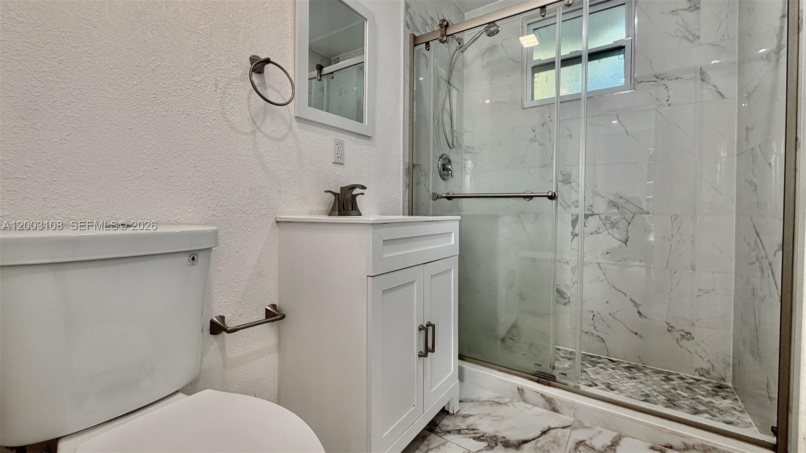 12435 Southwest 42nd Street, Unit 1 Miami, FL 33175 - Photo 4 of 7 a bathroom with a shower toilet and sink