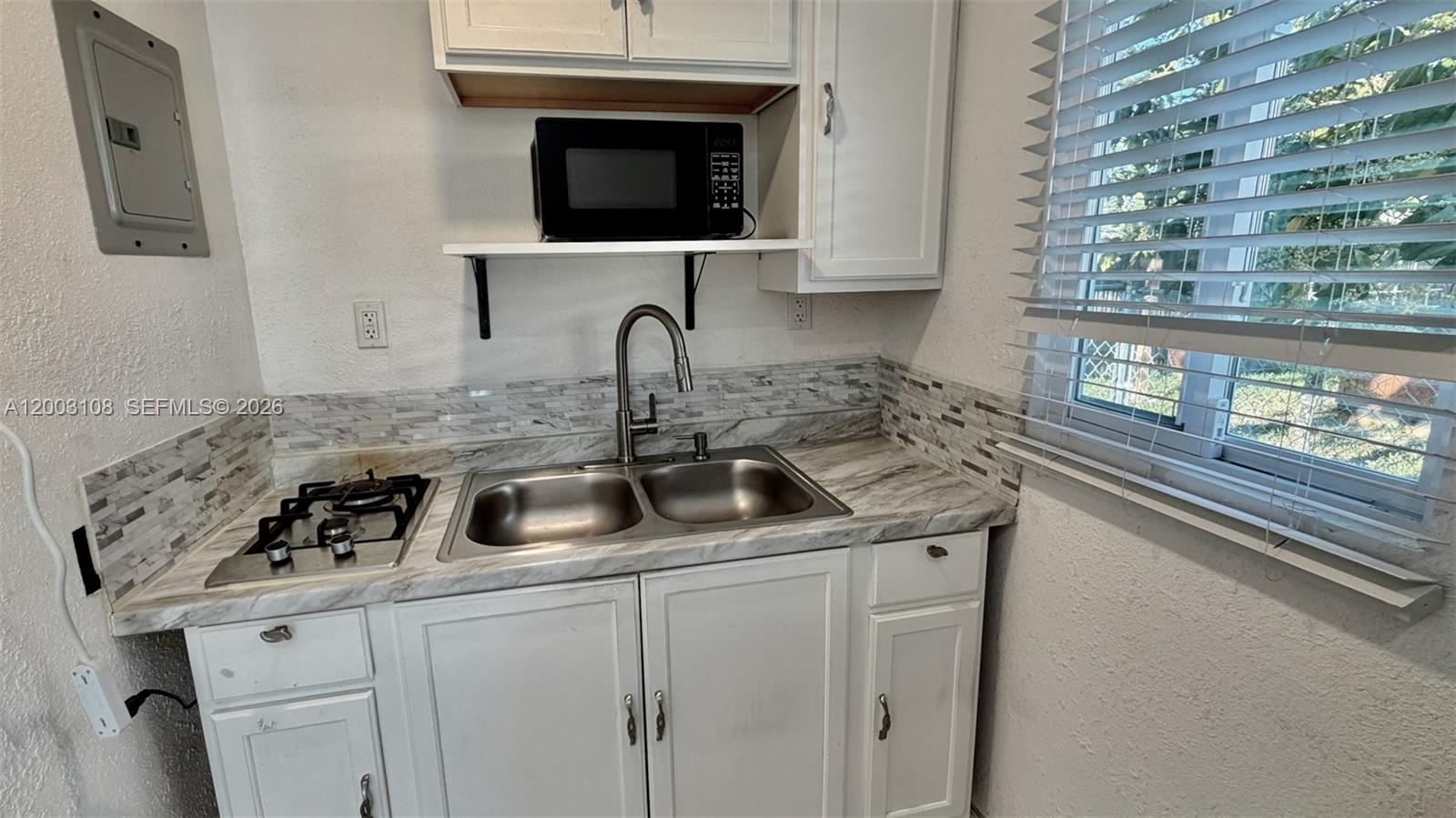12435 Southwest 42nd Street, Unit 1 Miami, FL 33175 - Photo 5 of 7 a kitchen with a sink and a stove with cabinets