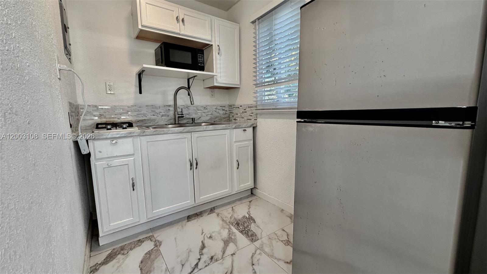12435 Southwest 42nd Street, Unit 1 Miami, FL 33175 - Photo 6 of 7 a bathroom with a sink and a mirror
