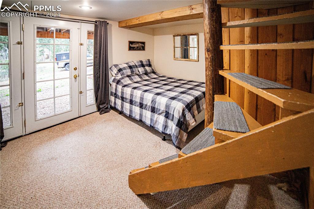 5870 Paona Road Cascade, CO 80809 - Photo 19 of 27 a bedroom with a bed and wooden floor