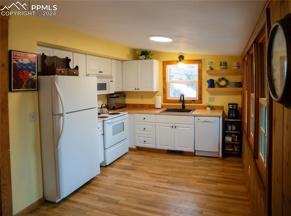 5870 Paona Road Cascade, CO 80809 - Photo 6 of 27 a kitchen with stainless steel appliances a refrigerator sink and cabinets