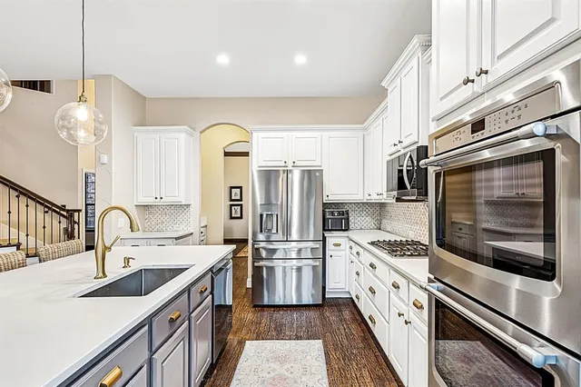 a kitchen with stainless steel appliances granite countertop a sink and a refrigerator