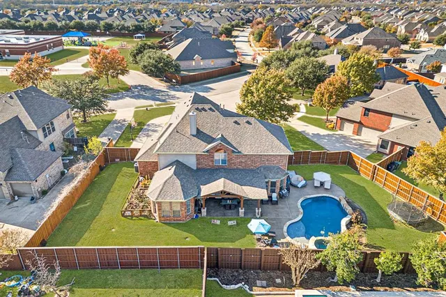 an aerial view of residential houses with yard