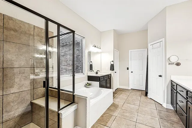 a spacious bathroom with a tub sink and mirror