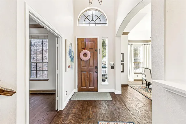 a view of a hallway with wooden floor and windows