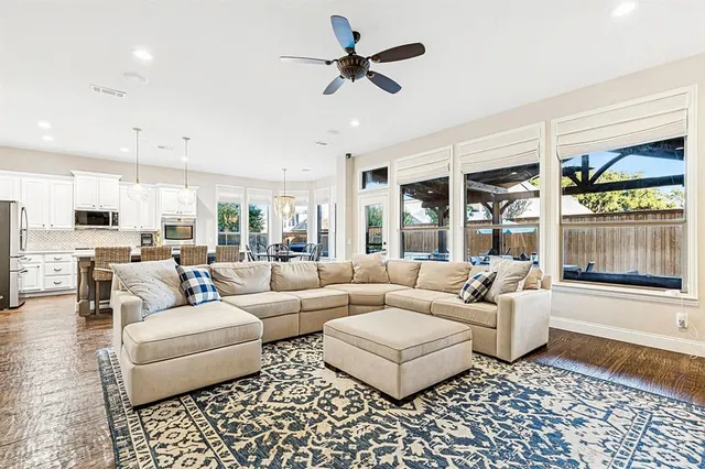 a living room with furniture and a large window with wooden floor
