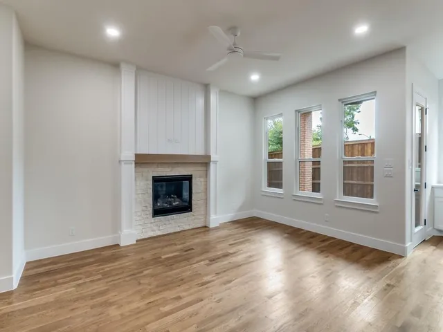 a view of an empty room with glass door and wooden floor