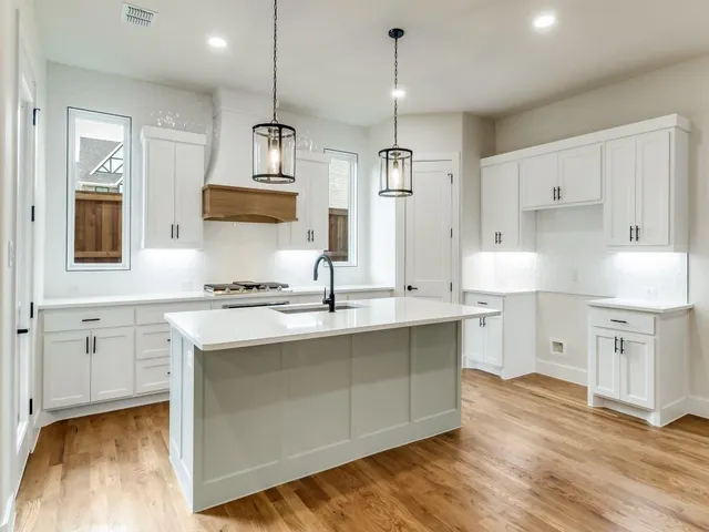 a kitchen with a sink cabinets and wooden floor