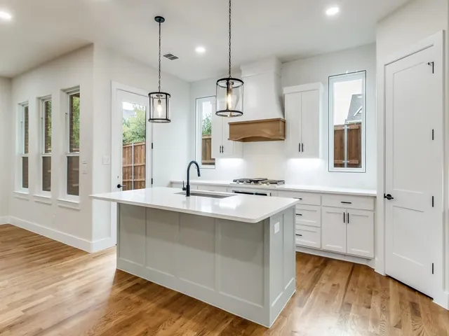 a kitchen with white cabinets and sink