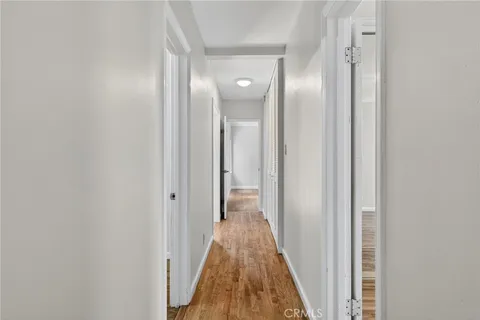 a view of a hallway with wooden floor