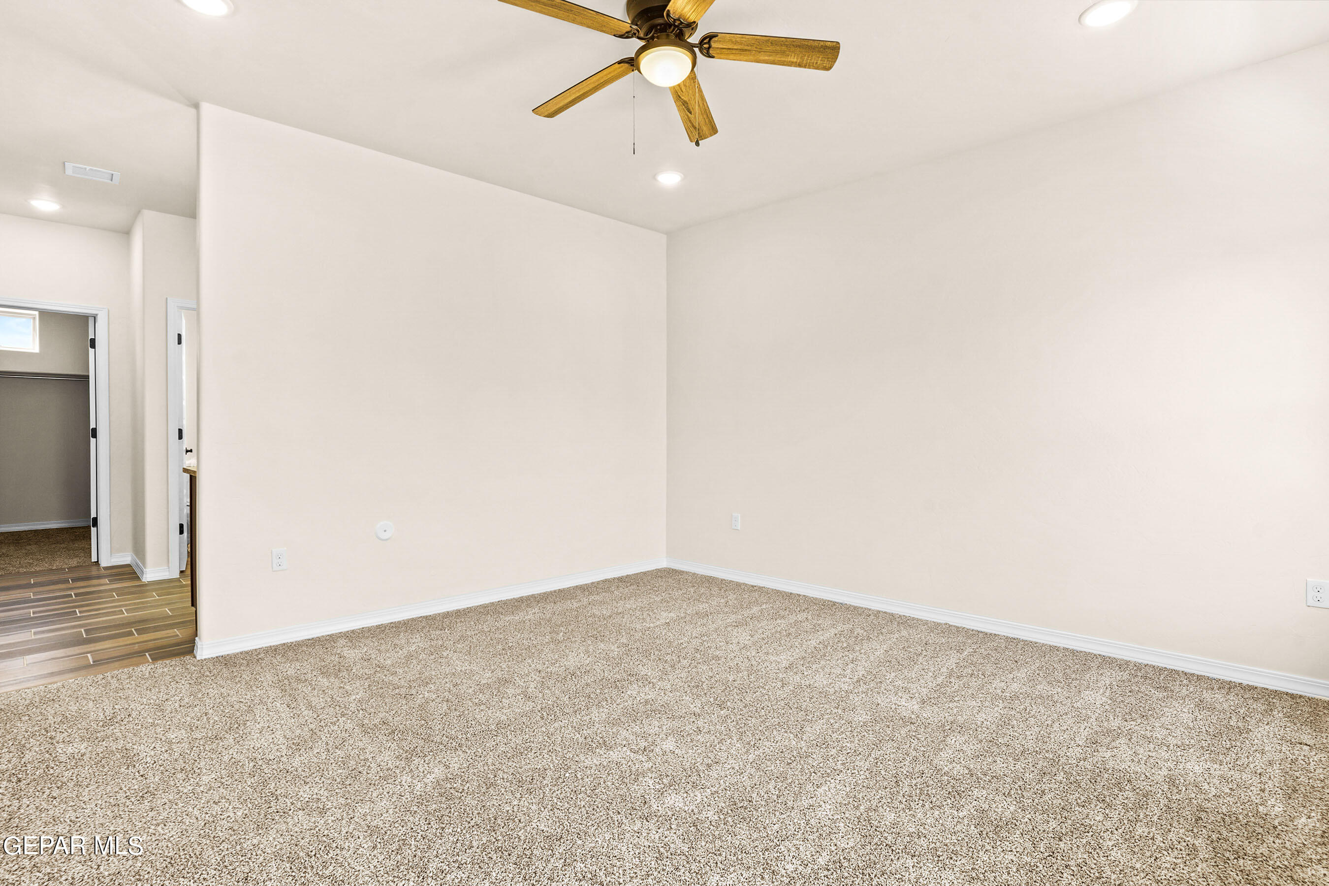 871 Country Club Road, Unit 4E El Paso, TX 79932 - Photo 17 of 34 an empty room with a ceiling fan and carpet