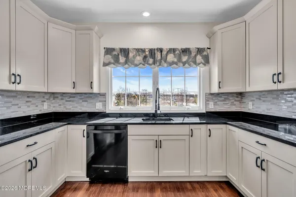 a kitchen with granite countertop white cabinets and white appliances