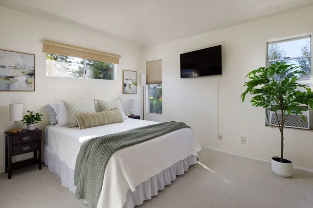 a bedroom with a bed and a potted plant