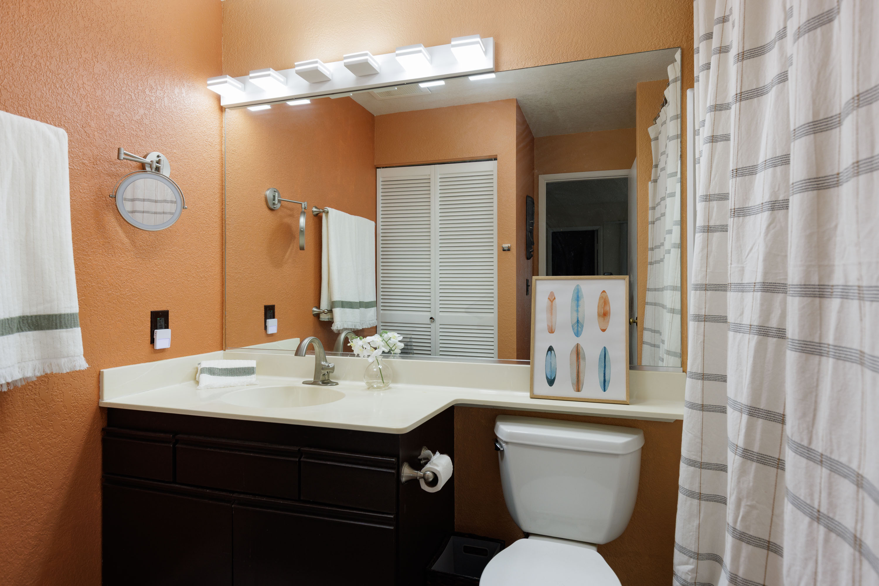 68-3890 Lua Kula Street, Unit 1408 Waikoloa, HI 96738 - Photo 16 of 22 a bathroom with a sink a toilet a mirror and shower curtain