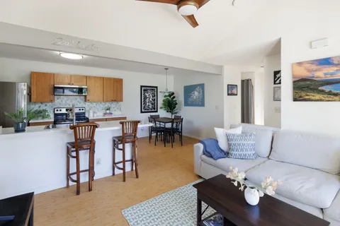 a living room with furniture and kitchen view