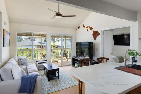 a living room with furniture a flat screen tv and a large window