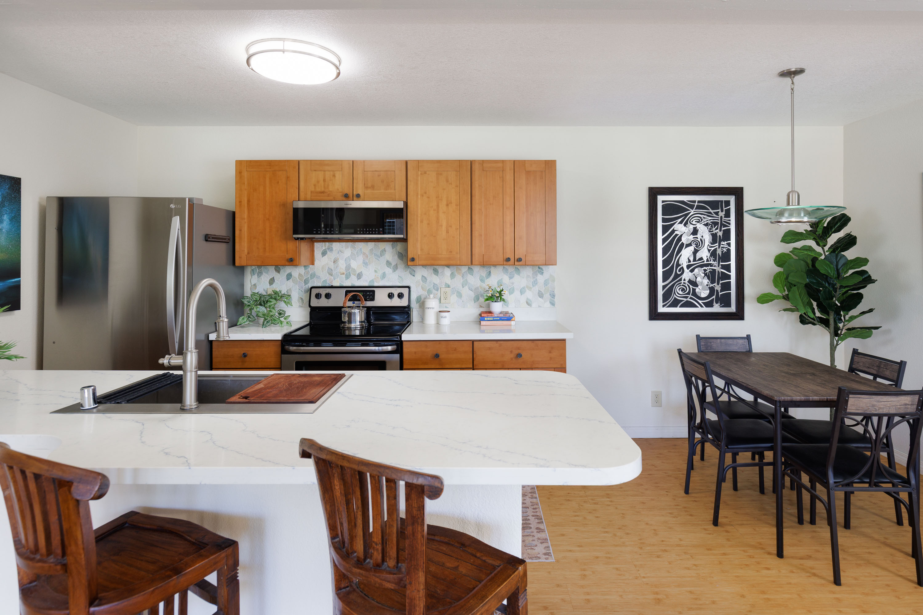 68-3890 Lua Kula Street, Unit 1408 Waikoloa, HI 96738 - Photo 5 of 22 a kitchen with a table chairs a refrigerator and a stove