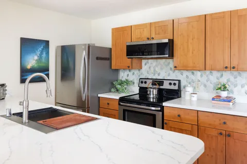 a kitchen with stainless steel appliances a stove a sink and a microwave