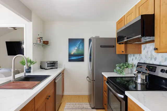 a kitchen with stainless steel appliances granite countertop a sink and a stove