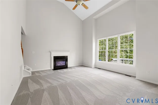 a view of an empty room with wooden floor and a fireplace