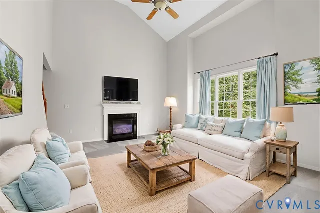 a living room with furniture a fireplace and a large window