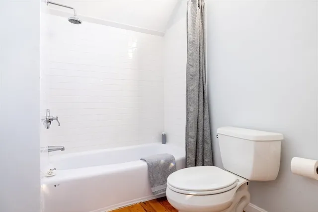 a white toilet sitting next to a bath tub