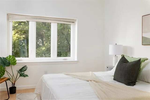 a bedroom with a bed and a potted plant