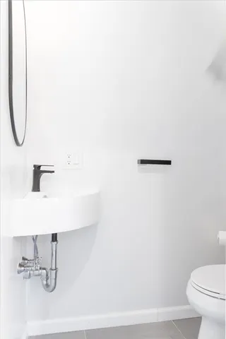 a bathroom with a sink a toilet and a mirror