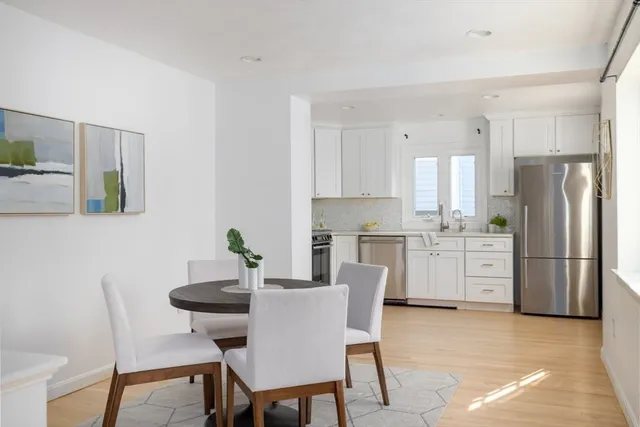 a kitchen with white cabinets and stainless steel appliances