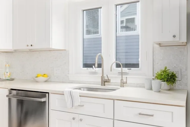 a kitchen with stainless steel appliances white cabinets and a sink
