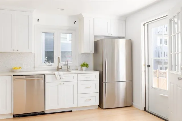 a kitchen with white cabinets and white stainless steel appliances