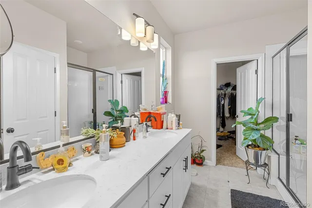 a bathroom with a sink a faucet a potted plant and a mirror