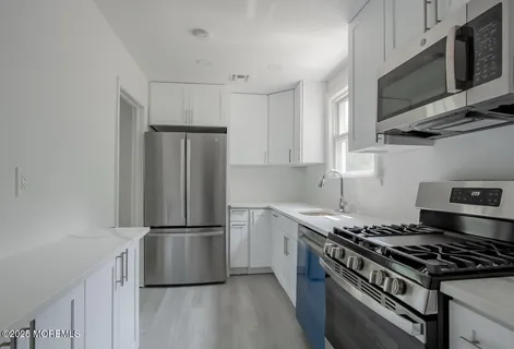 a kitchen with stainless steel appliances granite countertop a stove a refrigerator and a microwave