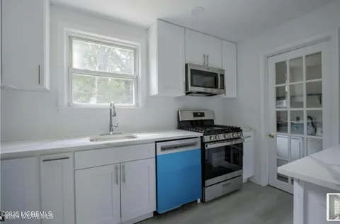 a kitchen with white cabinets stainless steel appliances and sink