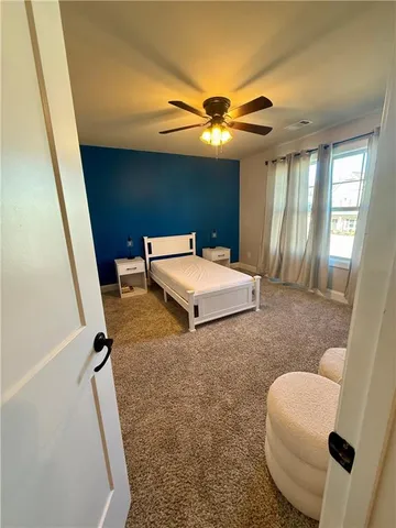 a bedroom with a bed and a large window