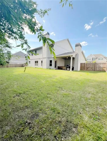 a front view of a house with a yard and trees