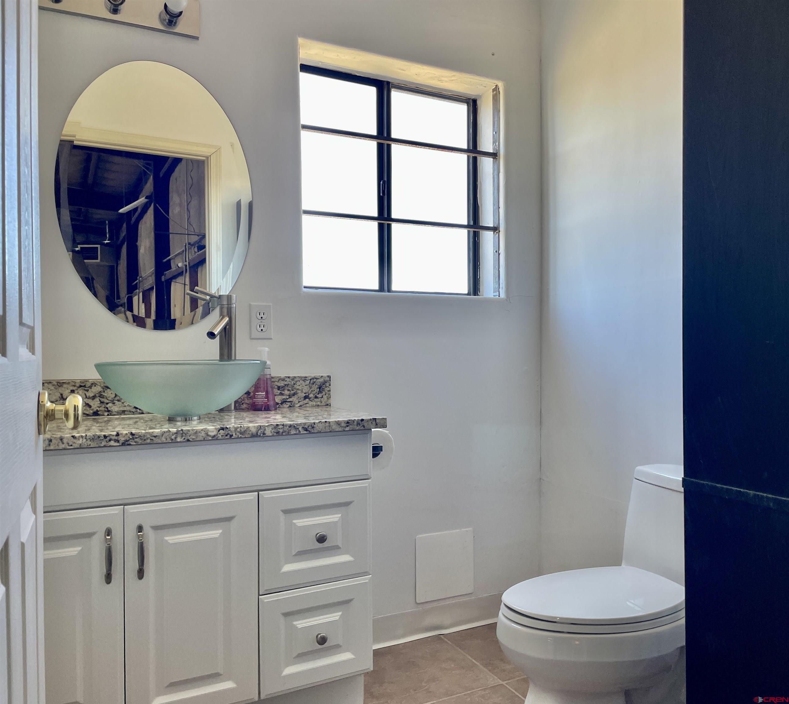1791 Industrial Road Cortez, CO 81321 - Photo 21 of 42 a bathroom with a toilet sink and mirror