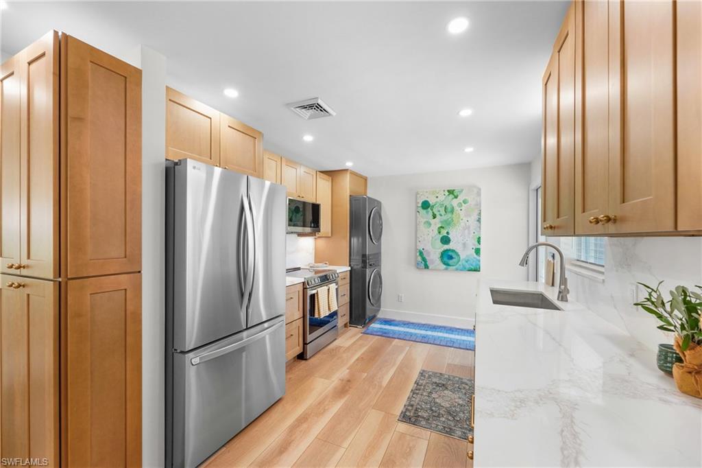 2855 10th Street North Naples, FL 34103 - Photo 13 of 29 a kitchen with stainless steel appliances a refrigerator and wooden floor