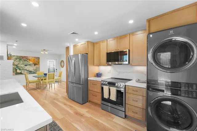 a kitchen with a refrigerator a stove top oven a sink and cabinets