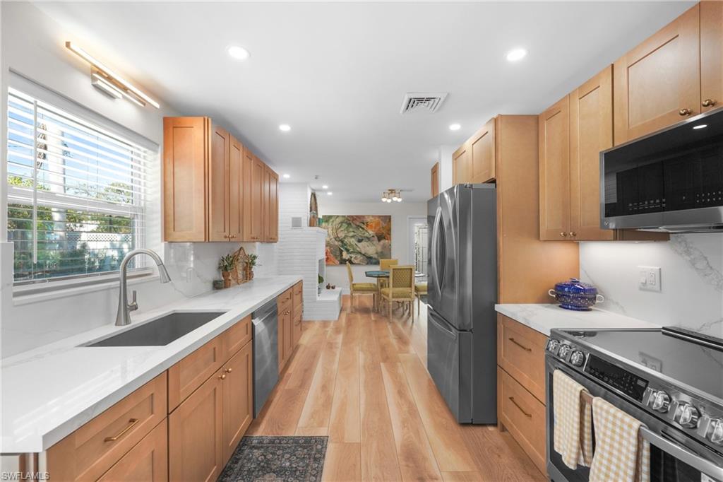 2855 10th Street North Naples, FL 34103 - Photo 15 of 29 a kitchen with stainless steel appliances a sink stove and refrigerator