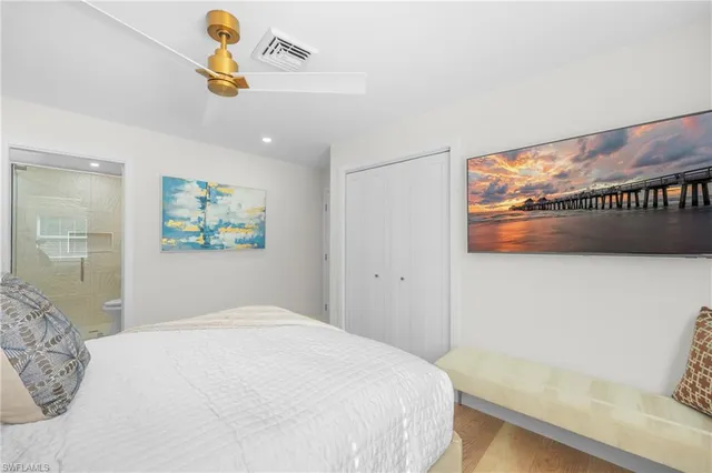 a bedroom with a bed and painting on the wall