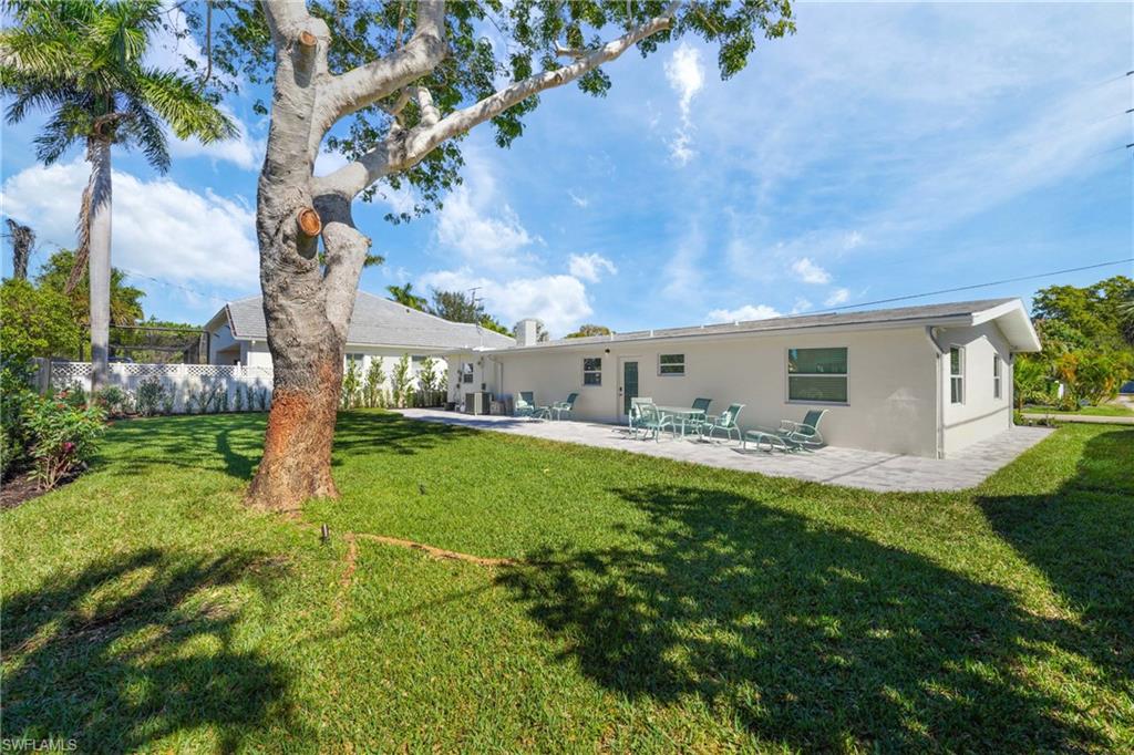 2855 10th Street North Naples, FL 34103 - Photo 24 of 29 a backyard of a house with table and chairs plants and large tree