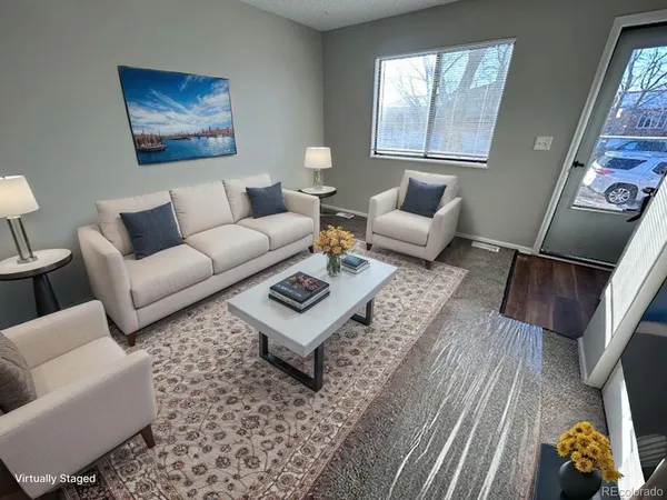 a living room with furniture a rug and a window