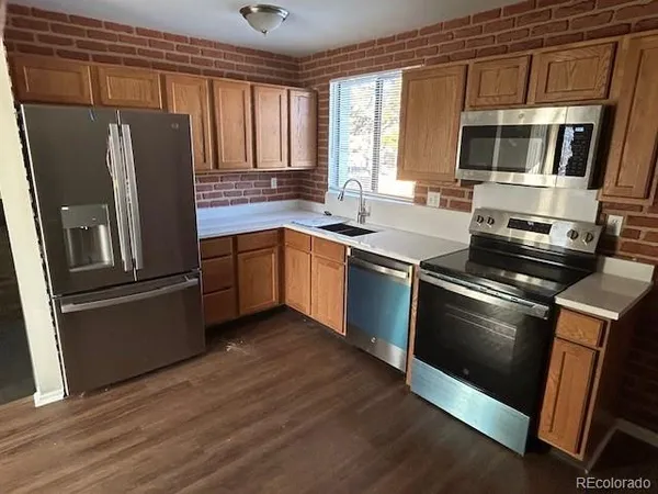 a kitchen with stainless steel appliances granite countertop a refrigerator stove and sink
