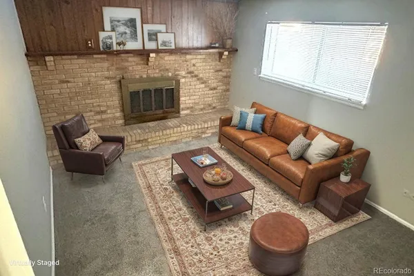 a living room with furniture a fireplace and a window
