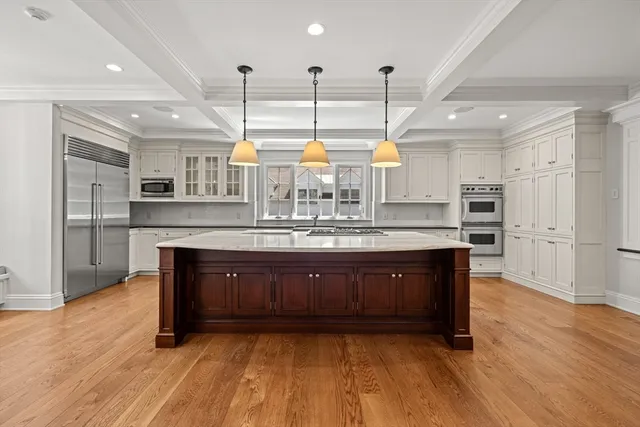 a large kitchen with wooden floors and stainless steel appliances