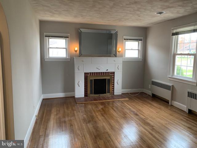 205 Twin Oaks Road Linthicum, MD 21090 - Photo 3 of 16 an empty room with wooden floor a fireplace and windows