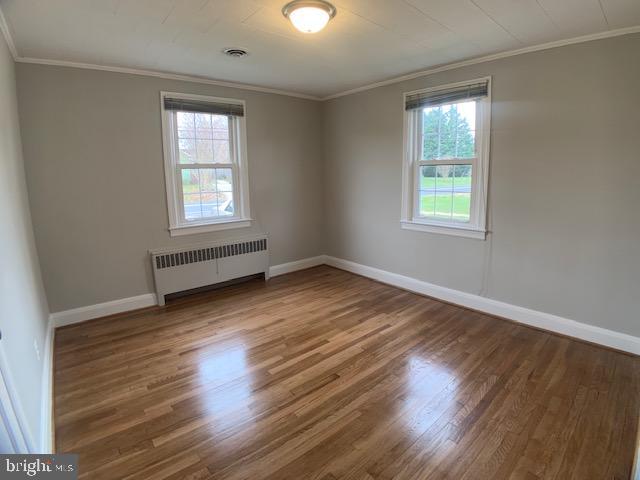 205 Twin Oaks Road Linthicum, MD 21090 - Photo 6 of 16 an empty room with wooden floor and windows