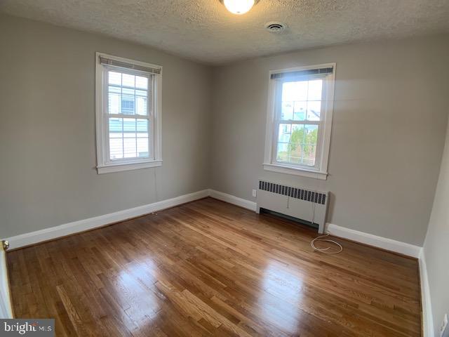 205 Twin Oaks Road Linthicum, MD 21090 - Photo 7 of 16 an empty room with wooden floor and windows